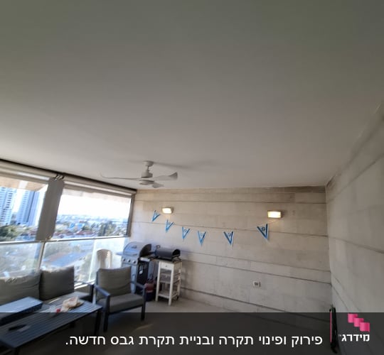 מרפסת עם ריהוט גן ודגלים על הקיר